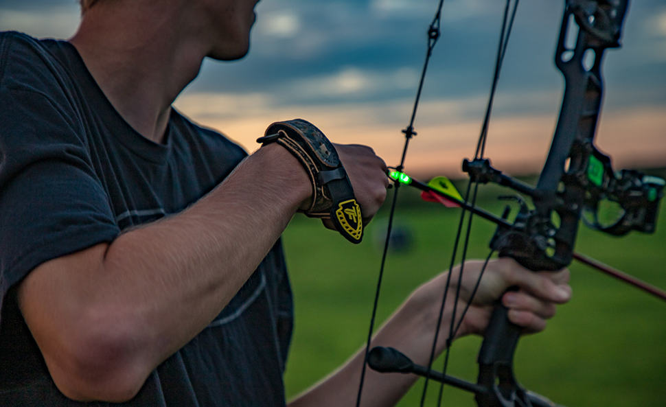 Nockturnal-img person holding knocked arrow with lighted green tip
